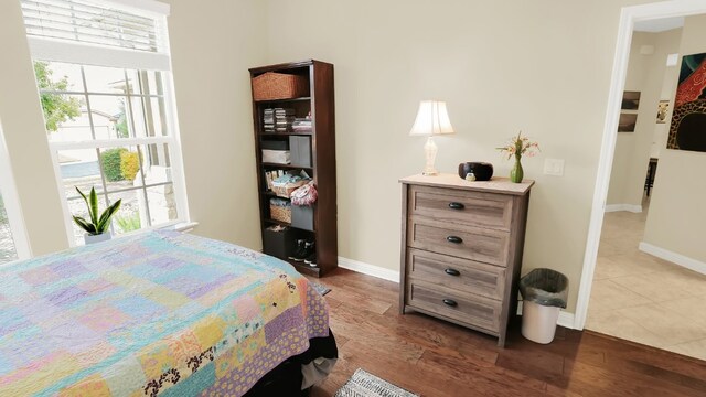 bedroom featuring dark wood-style flooring, multiple windows, and baseboards