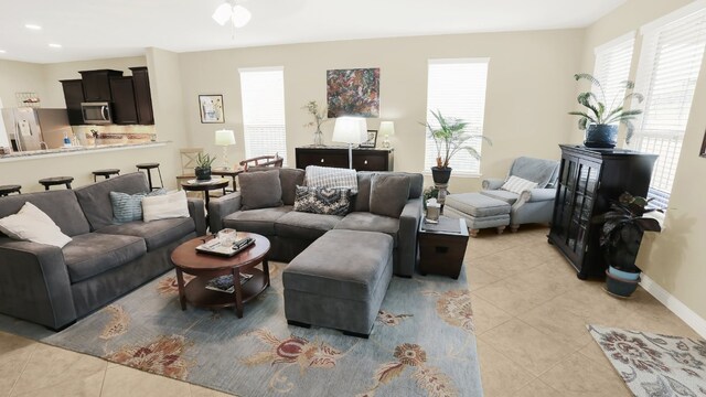 living room featuring a wealth of natural light, light tile patterned flooring, and baseboards