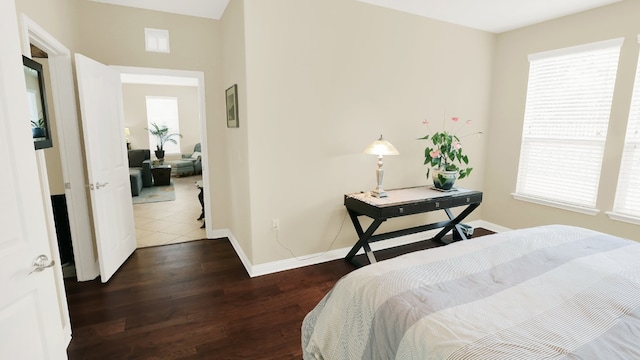 bedroom featuring visible vents, baseboards, and wood finished floors