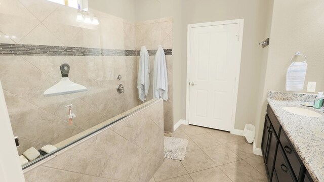 full bathroom with tile patterned floors, baseboards, a walk in shower, and vanity