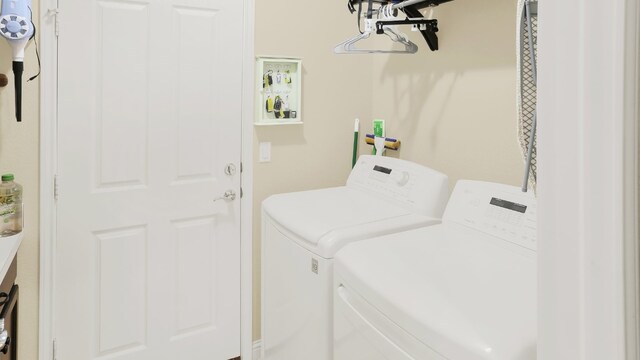 clothes washing area featuring laundry area and washer and clothes dryer