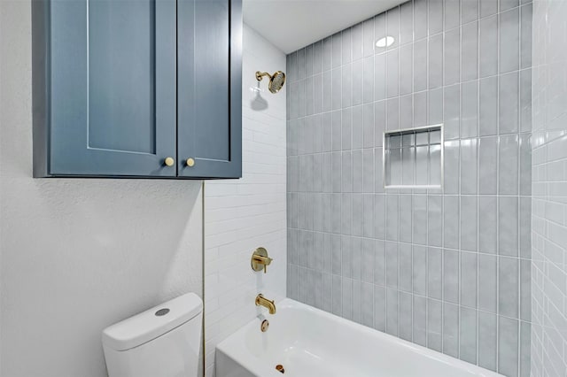 bathroom featuring tiled shower / bath combo and toilet