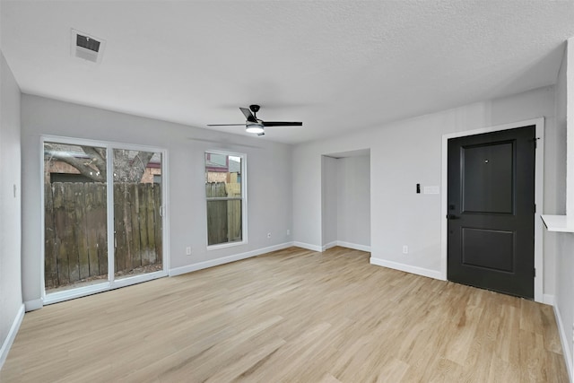 spare room with a textured ceiling, light hardwood / wood-style flooring, and ceiling fan