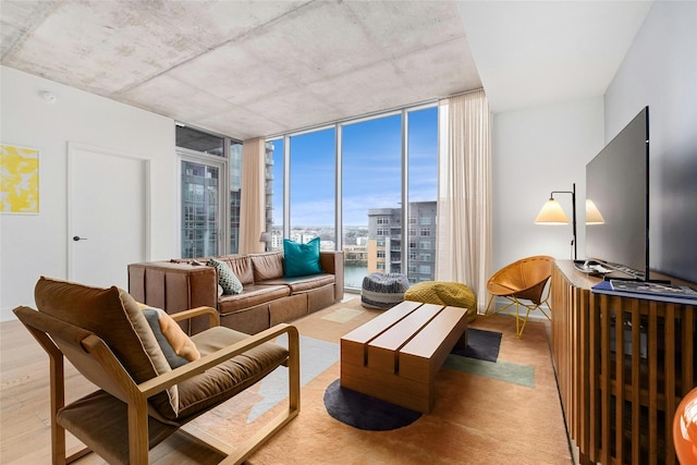 living room featuring light wood-type flooring and floor to ceiling windows