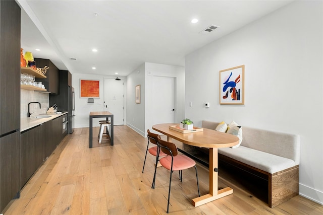 dining room featuring sink, breakfast area, and light hardwood / wood-style flooring