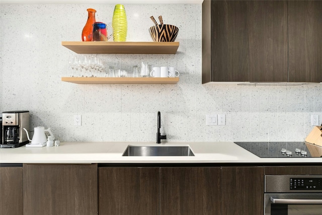 kitchen featuring sink, black electric stovetop, dark brown cabinets, and stainless steel oven