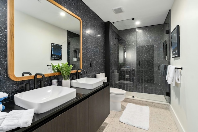 bathroom featuring vanity, toilet, and a shower with shower door