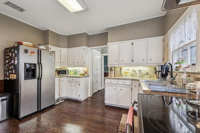 kitchen with dark hardwood / wood-style flooring, sink, appliances with stainless steel finishes, backsplash, and white cabinetry