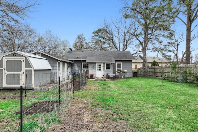 rear view of property with a yard and a storage unit