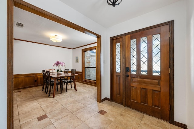 entrance foyer featuring crown molding and wooden walls