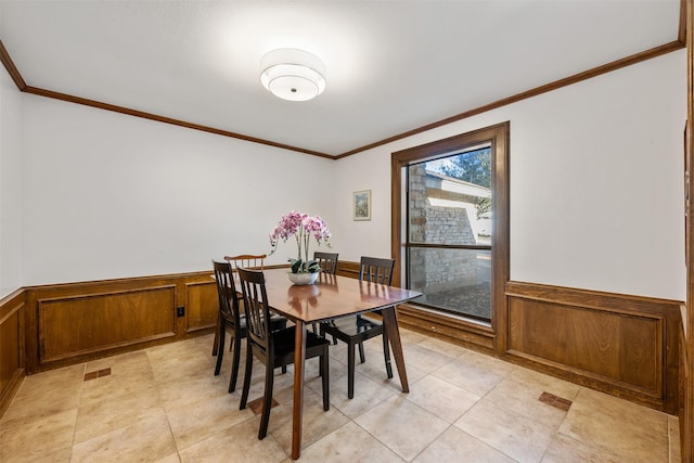 dining room with wooden walls and ornamental molding