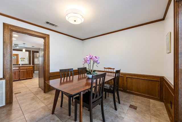 tiled dining space featuring ornamental molding