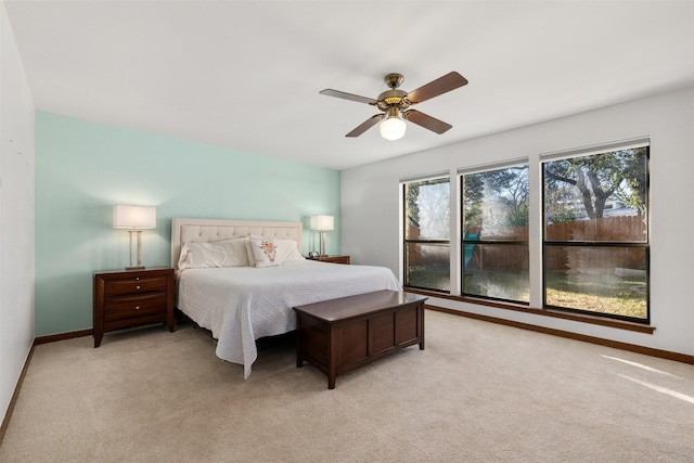 bedroom with multiple windows, light colored carpet, and ceiling fan