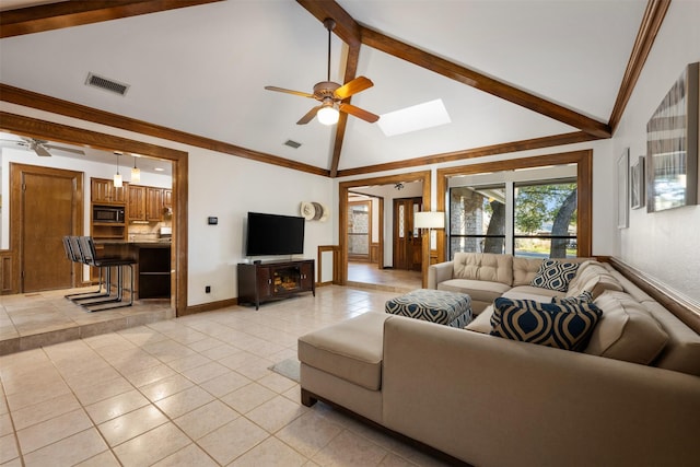 living room with light tile patterned flooring, ceiling fan, and lofted ceiling with skylight