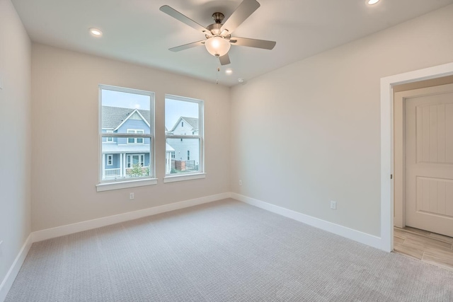 spare room with light carpet and ceiling fan