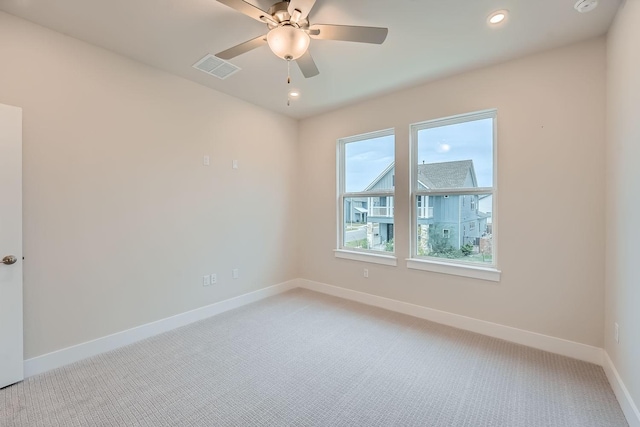 spare room with ceiling fan and carpet