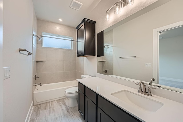 full bathroom featuring toilet, vanity, and tiled shower / bath combo