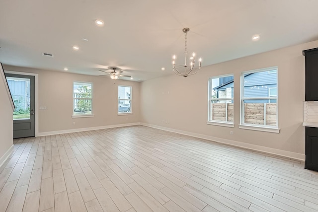 unfurnished living room featuring ceiling fan with notable chandelier and light hardwood / wood-style flooring