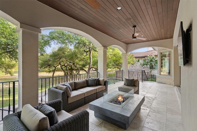 view of patio / terrace featuring ceiling fan and an outdoor living space with a fire pit