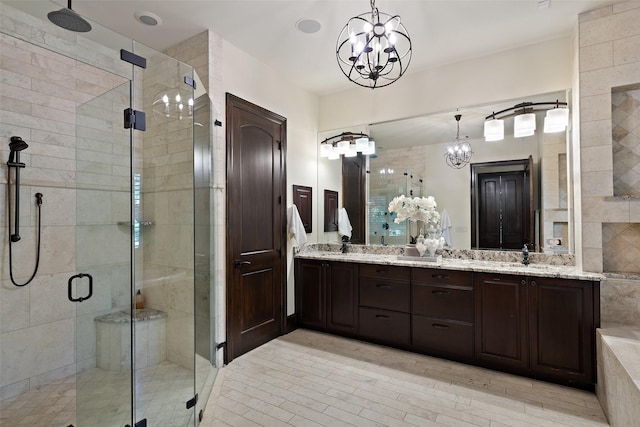 bathroom featuring an enclosed shower, vanity, and an inviting chandelier