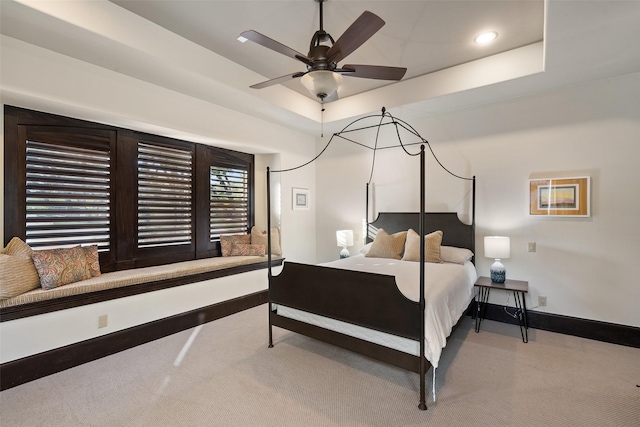 bedroom with ceiling fan, carpet, and a raised ceiling