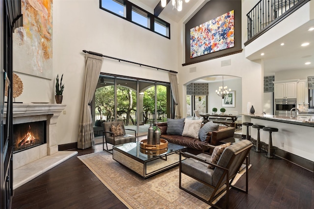 interior space featuring wood-type flooring, a premium fireplace, and a towering ceiling