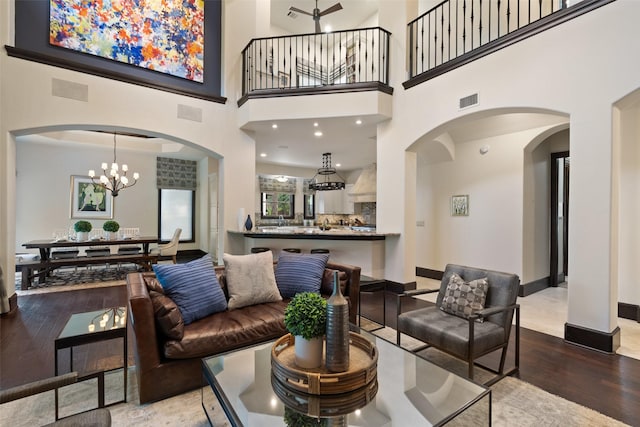 living room featuring hardwood / wood-style flooring, a high ceiling, and a notable chandelier