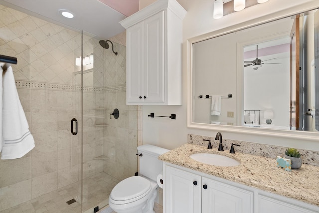 bathroom featuring vanity, toilet, ceiling fan, and an enclosed shower