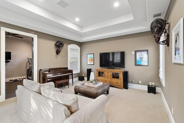 living room with light carpet and a raised ceiling