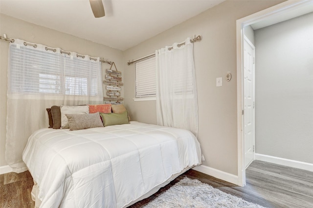 bedroom with ceiling fan, baseboards, and wood finished floors