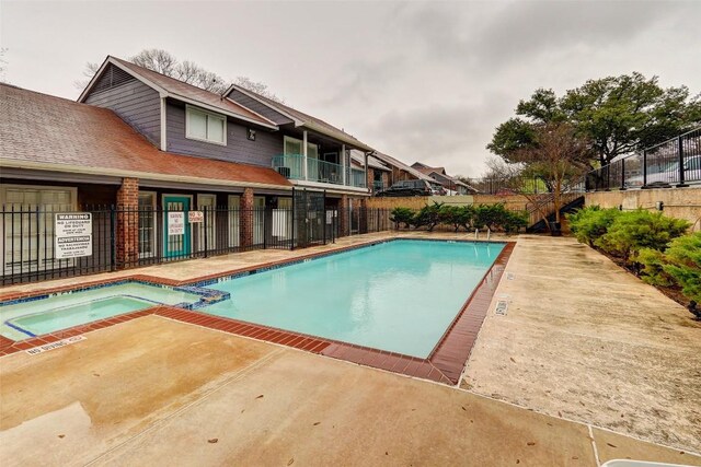 view of swimming pool featuring a patio area and a hot tub