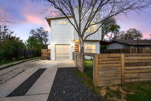 property exterior at dusk featuring a garage