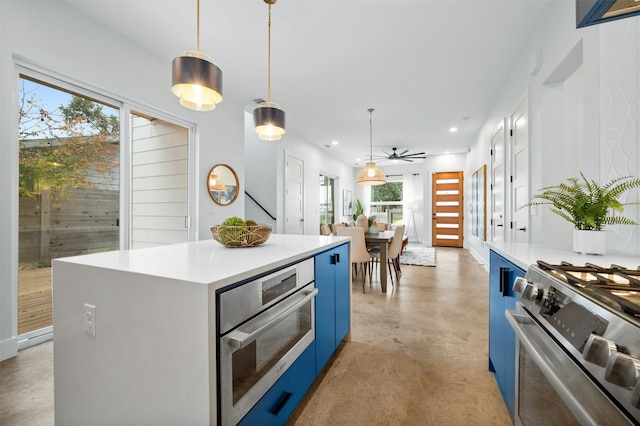 kitchen featuring decorative light fixtures, blue cabinetry, a center island, and appliances with stainless steel finishes