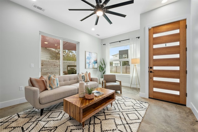 living room with ceiling fan and a wealth of natural light