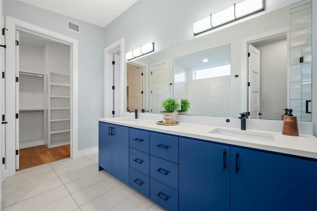 bathroom featuring tile patterned floors, walk in shower, and vanity