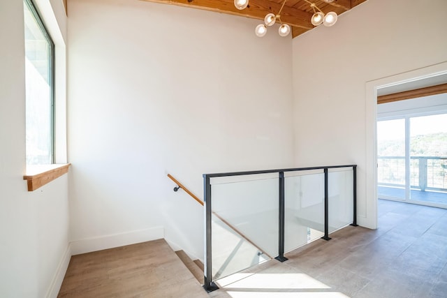 stairway with hardwood / wood-style flooring, wooden ceiling, and beam ceiling