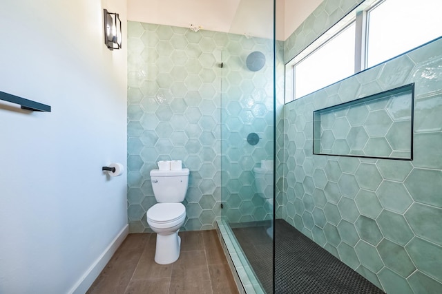 bathroom with toilet, tile walls, and a tile shower