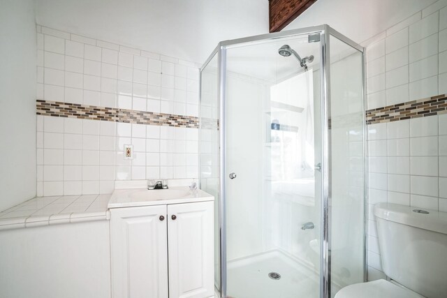 bathroom with toilet, a shower with shower door, and vanity