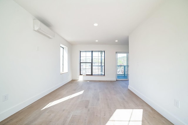 spare room featuring light hardwood / wood-style floors and a wall mounted AC