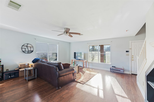 living room with ceiling fan and dark wood-type flooring