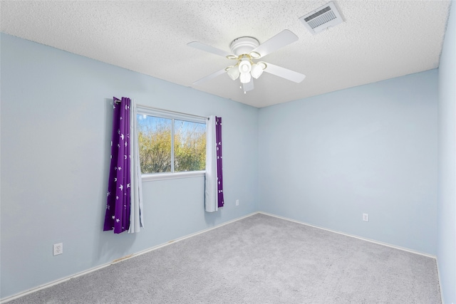 carpeted spare room with ceiling fan and a textured ceiling