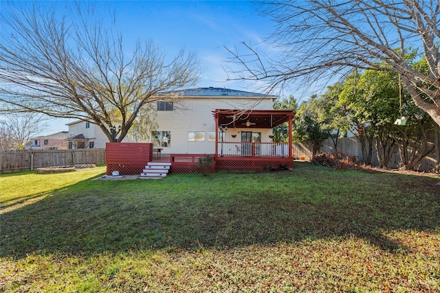 rear view of house with a wooden deck and a yard