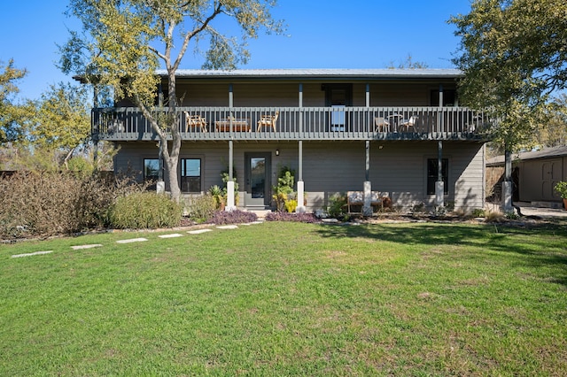 back of property featuring a wooden deck and a yard