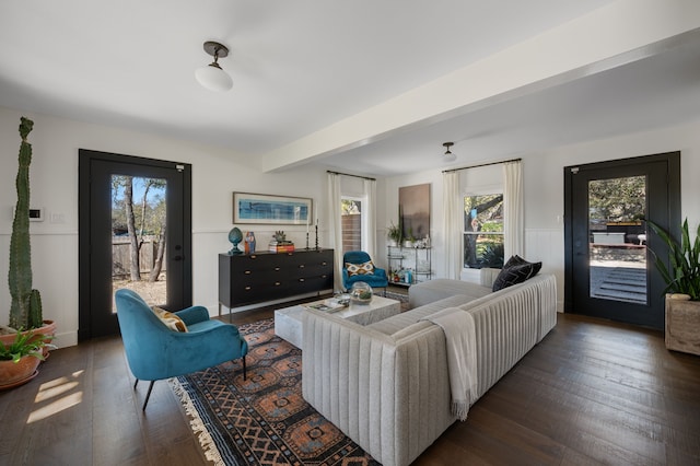 living room featuring a healthy amount of sunlight, beam ceiling, and dark hardwood / wood-style floors