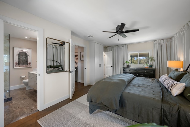 bedroom featuring ceiling fan, dark wood-type flooring, and connected bathroom