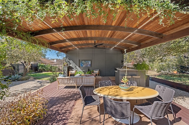 view of patio / terrace featuring outdoor lounge area, ceiling fan, a deck, and exterior bar