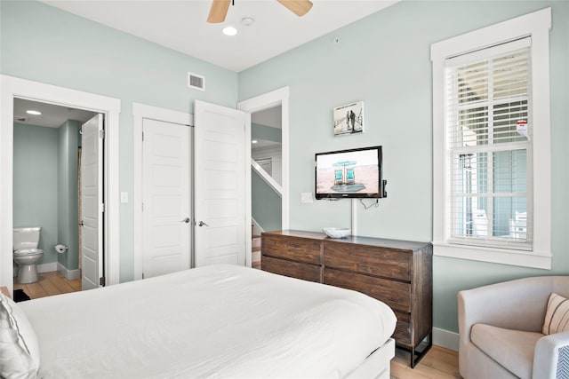 bedroom with ceiling fan, a closet, light hardwood / wood-style flooring, and ensuite bath
