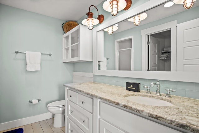 bathroom featuring vanity, toilet, and a shower with door