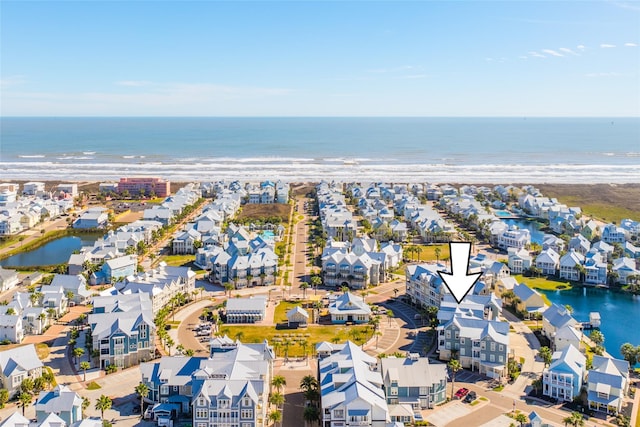 birds eye view of property featuring a water view and a beach view