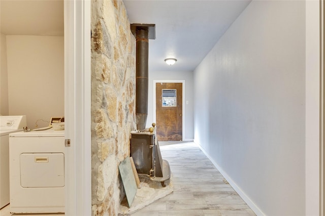 corridor with washer / dryer and light hardwood / wood-style flooring